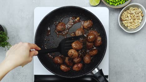 Woman-cooking-meatballs-on-frying-pan-with-oil
