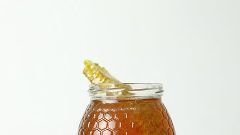 Honey-with-honeycomb-in-glass-jar