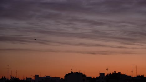 Hubschrauber-Gegen-Den-Farbenprächtigen-Sonnenuntergangshimmel-über-Der-Stadt
