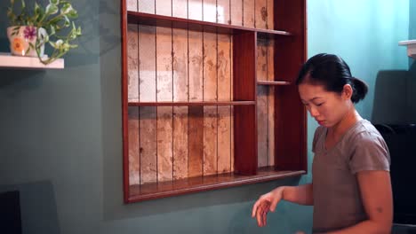 Ethnic-woman-renovating-wooden-shelves-at-home