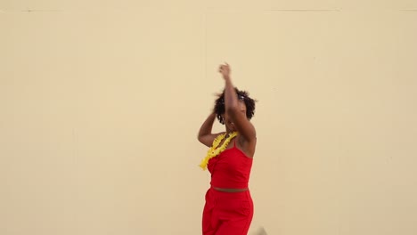 Happy-African-American-woman-dancing-near-white-wall