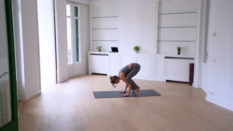 Frau-Macht-Yoga-Auf-Einer-Matte-In-Einem-Geräumigen-Raum
