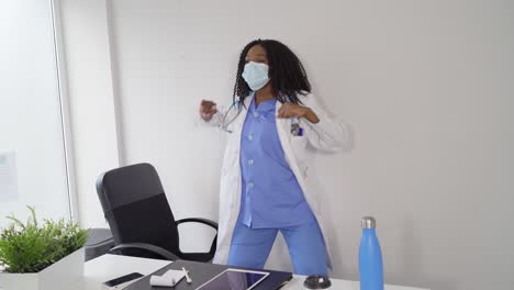 Schwarze-Ärztin-Mit-Medizinischer-Maske-Tanzt-In-Der-Klinik