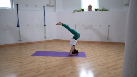 Woman-performing-Supported-Headstand-with-Splits-pose-in-room
