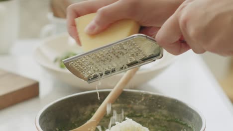 Crop-woman-grating-cheese-for-pasta