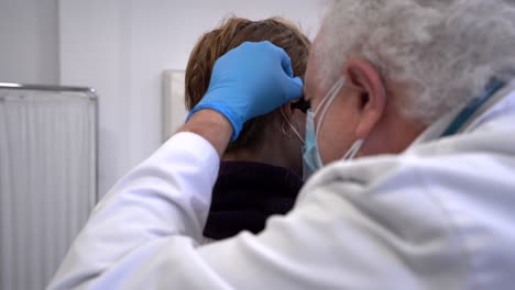 Arzt-Verwendet-Otoskop-Zur-Untersuchung-Der-Ohren-Des-Patienten