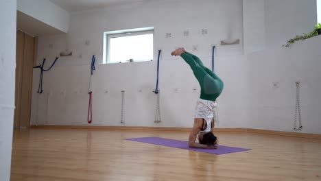 Woman-performing-Supported-Headstand-with-Splits-pose-in-room