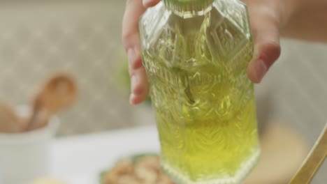 Crop-Lady-Fügt-Olivenöl-Zu-Leckeren-Nudeln-In-Der-Pfanne-Hinzu