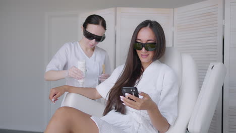 Laser-epilation.-Woman-getting-laser-hair-removal-procedure-on-her-legs.-Beauty-laser-treatment-salon-clinic-cosmetology-beautician-professional-profession-body-care-concept
