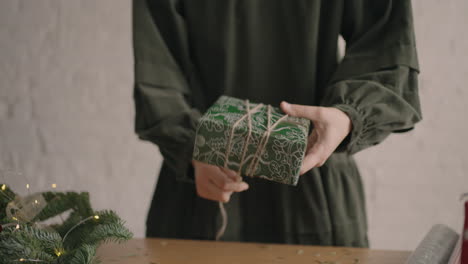 Nahaufnahmemädchen-Verpackt-Ein-Geschenk-Und-Bindet-Es-Mit-Einem-Seil