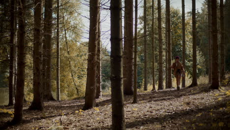 Woman-walking-amidst-trees-in-forest-during-summer
