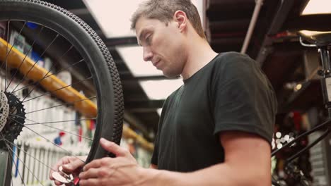 Crop-mechanic-using-wrench-and-adjusting-bicycle-wheel-spokes