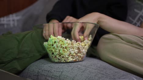 Anonymes-Paar-Sitzt-Auf-Dem-Sofa-Und-Isst-Popcorn