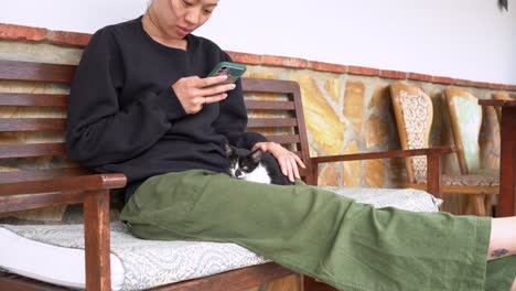 Glückliche-Asiatische-Frau-Mit-Kätzchen,-Die-Auf-Dem-Smartphone-Surft