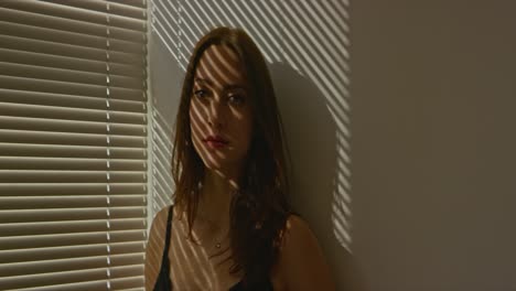 Woman-posing-in-shadows-of-blinds