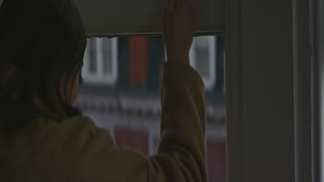 Woman-opening-window-in-apartment-in-the-morning