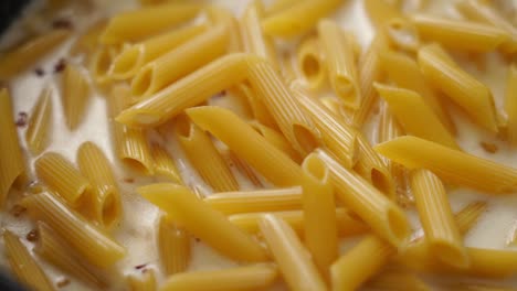 Cook-adding-cream-to-boiling-pasta