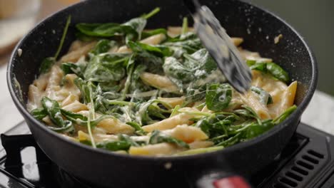 Crop-person-preparing-pasta-in-frying-pan