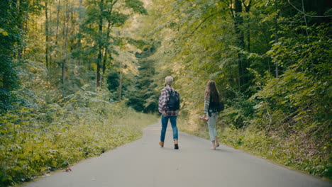 Carefree-Friends-Walking-Amidst-Trees-In-Forest