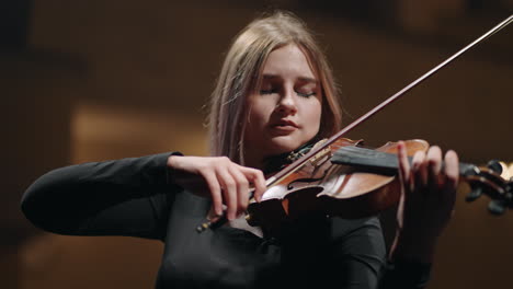 La-Joven-Está-Tocando-El-Violín-En-El-Music-Hall.-La-Músico-Está-Ensayando-Con-El-Violinista-En-Escena.