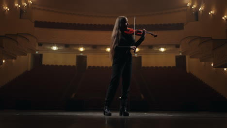 Frau-Geiger-Spielt-Geige-In-Der-Philharmonie-Dunkle-Silhouette-Auf-Der-Bühne