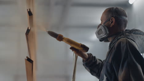 Molar-sprays-paint-on-steel-profiles-in-a-respirator-mask-and-protective-suit-in-slow-motion