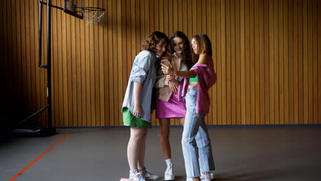 Chicas-Con-Smartphone-En-El-Gimnasio-De-La-Escuela.