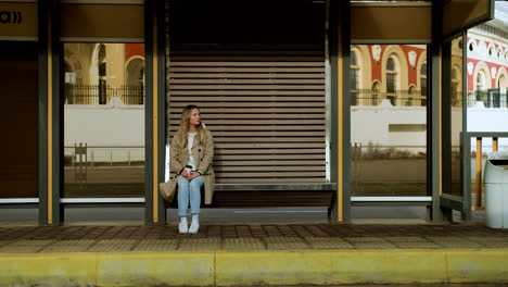 Young-woman-sitting-at-bus-stop