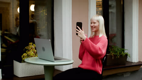 Blond-woman-videocalling-at-the-terrace