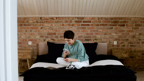 Woman-using-phone-on-bed