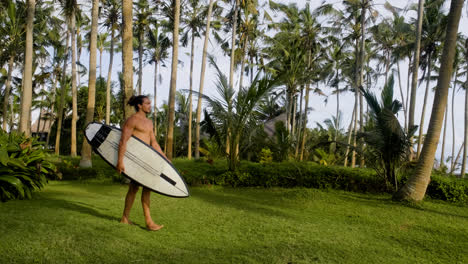 Man-walking-and-holding-surfboard