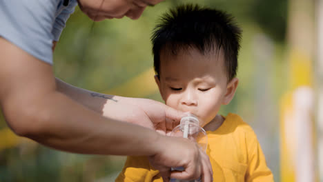 Niño-Asiático-Bebiendo-Agua-De-Una-Botella