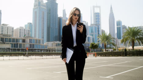 Elegant-businesswoman-with-phone-outdoors