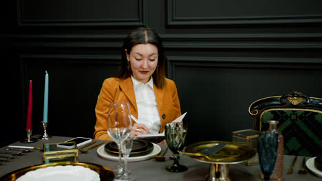 Asian-woman-sitting-at-elegant-table