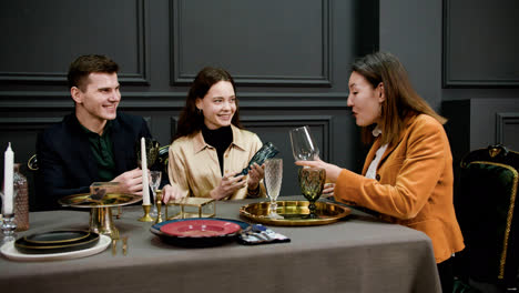 Asian-woman-talking-with-a-couple-sitting-at-a-table