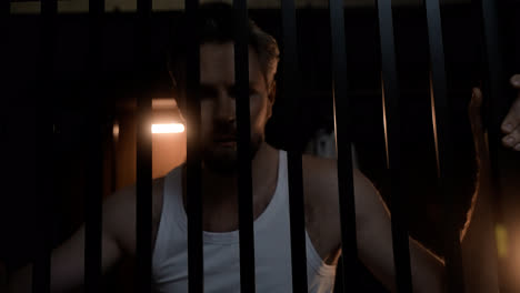 Closeup-of-man-behind-bars