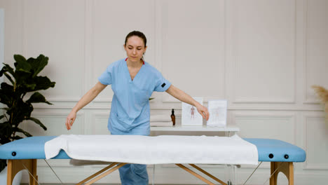 Physiotherapist-preparing-the-massage-room