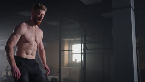 Slow-motion:-Muscular-Shirtless-Fit-Man-Energetically-Box-Jumps-in-Hardcore-Gym-doing-Part-of-His-Cross-Fitness-Training-Plan.-Man-is-Sweaty-from-Intense-Workout