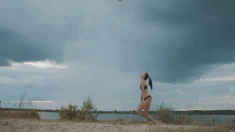 Beachvolleyball-In-Der-Natur-Junge-Frau-Spielt-Ball-Auf-Dem-Platz-Gegen-Bewölkten-Himmel-Athletin-Und-Sportlerin