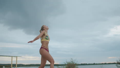 slim-and-active-sportswoman-is-playing-beach-volleyball-at-nature-slow-motion-shot-against-cloudy-sky
