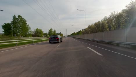 Front-facing-footage-of-a-car-driving-at-high-speed-along-a-highway-in-a-busy-commercial-area