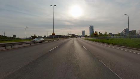 Driving-fast-on-a-motorway-while-approaching-a-tunnel-leading-into-a-city