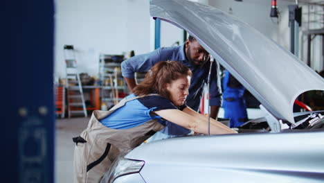 Mechanic-in-garage-cleans-customers-car
