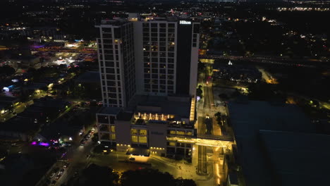 Aerial-view-toward-the-illuminated-Hilton-Austin-hotel,-nighttime-in-Texas,-USA
