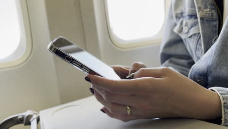 Caucasian-Female-Traveler-Texting-on-Cellphone-on-WestJet-Airplane,-at-LAX-Airport-on-7-13-2023