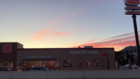 Outside-of-Burger-King-with-beautiful-sunset-and-pink-clouds-in-Estepona-Spain,-fast-food-restaurant,-4K-shot