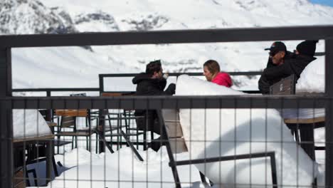 Sillas-De-Una-Tienda-Completamente-Enterrada-En-La-Nieve,-Gente-Disfrutando-De-Una-Cerveza-Con-Vista-Al-Parque-Farellones-Chile