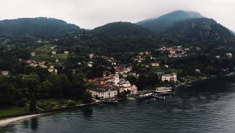 Vista-Aérea-De-La-Costa-De-Bellagio-Con-Estructuras-Italianas-Que-Bordean-El-Remoto-Lago