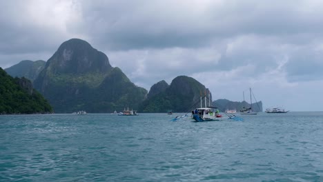 Stunning-view-of-tropical-islands-and-ocean-with-outrigger-tour-boats-during-island-hopping-tour-in-El-Nido,-Palawan-in-the-Philippines,-Southeast-Asia