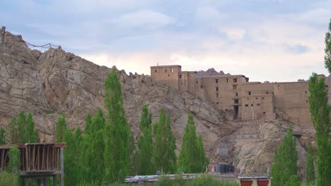 Pan-shot-of-Leh-Palace-or-Fort-and-trees-with-Upper-Himalayas-landscape-of-Leh-Ladakh-India